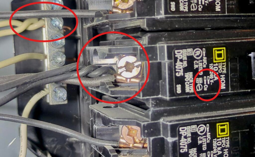 This Square D breaker is designed for two copper wires, never three. And check out the upper left—two neutral wires under one screw is another classic wiring no-no. Spotting these kinds of issues is exactly what professional home inspectors are trained to do.
